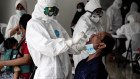 Health workers wearing take a PCR swab test on a man inside the Wisma Atlet Covid-19 Emergency Hospital complex in Jakarta. The 7394-bed hospital reached 90 per cent capcity this week.