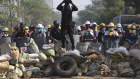 Protesters take positions behind a barricade as police gather in Yangon, Myanmar, in March.