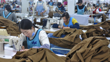 Workers sew clothing for export in Donghai county in east China's Jiangsu province. China's economic growth held steady in the latest quarter despite a tariff war with Washington, suggesting Beijing's efforts to reverse a slowdown might be gaining traction.