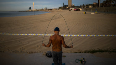 A man skips with a skipping rope next to a closed beach in Barcelona, Spain.