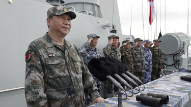 Chinese President Xi Jinping, left, reviews a Navy fleet in the South China Sea. 