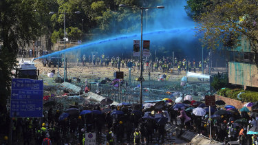 Police spray blue-dyed liquid from an armored vehicle during a confrontation with protesters at Hong Kong Polytechnic University.