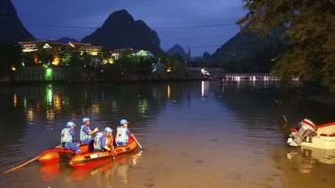 Rescuers search for missing boaters on the Taohua River in Guilin, in southern China.