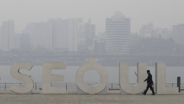 A man wearing a mask to protect himself from air pollution walks along the Han river at a park in Seoul, South Korea, on Tuesday.