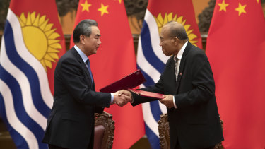 Chinese Foreign Minister Wang Yi, left, and Kiribati President Taneti Maamau shake hands during a signing ceremony at the Great Hall of the People in Beijing a year ago.