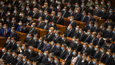 Attendees wearing face masks watch an event to honour some of those involved in China's fight against COVID-19 at the Great Hall of the People in Beijing.