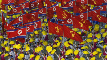 Dancers wave flags of North Korea and Korean Workers' Party as they perform during mass games. Such images are now replacing displays of military might.