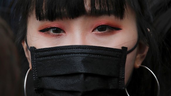 A protester with a mask gathers with others near the Legislative Council.