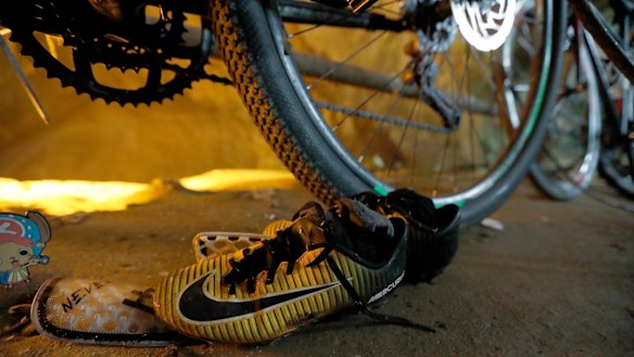 June 25, 2018: A pair of soccer boots lie next to the bicycles of the missing boys at the cave entrance in Chiang Rai, northern Thailand.