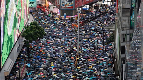 Demonstrators carry umbrellas as they march along a street in Hong Kong.