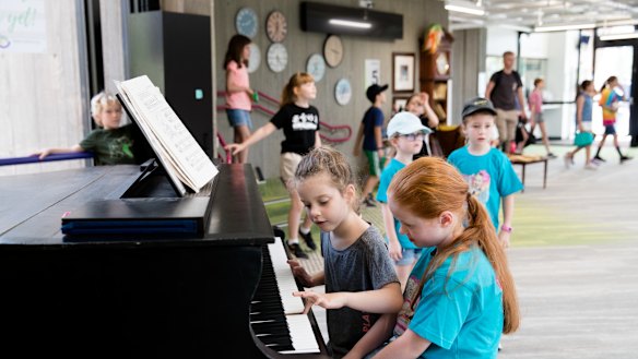 It takes a village: students play a grand piano during lunch time at Lindfield Learning Village.