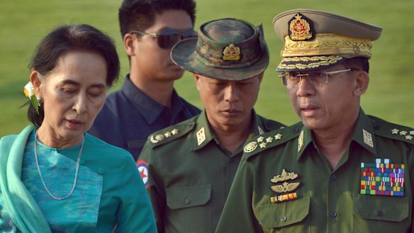 Aung San Suu Kyi, left, walks with Senior General Min Aung Hlaing, right, in 2016