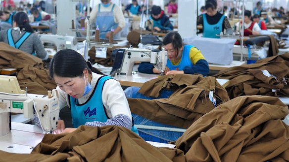 Workers sew clothing for export in Donghai county in east China's Jiangsu province. China's economic growth held steady in the latest quarter despite a tariff war with Washington, suggesting Beijing's efforts to reverse a slowdown might be gaining traction.