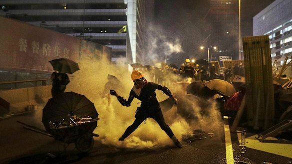 A protester throws a tear gas canister which was fired by riot police during a protest in Hong Kong on Sunday. 