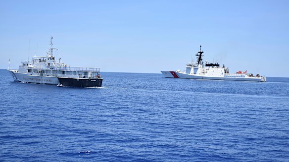 A US Coast Guard vessel, right, and a Philippines counterpart conduct joint exercises west of the Philippines last year.