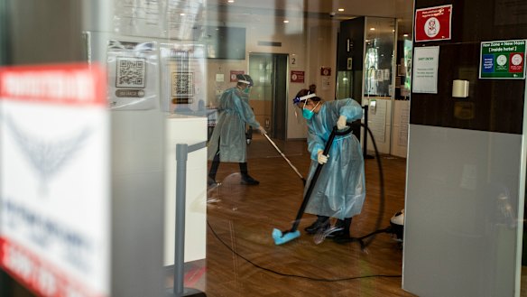 Cleaners wearing protective equipment disinfect the Holiday Inn quarantine hotel at Melbourne Airport this week.