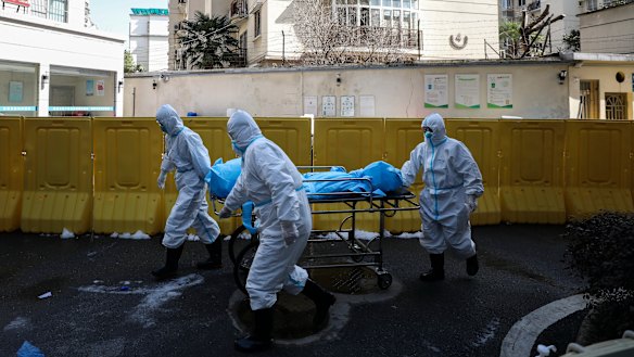 Medical workers move a person who died from COVID-19 at a hospital in Wuhan in central China's Hubei province. 