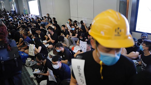 Demonstrators sit during a protest at the Yuen Long MTR station, where demonstrators and others were violently attacked by men in white T-shirts following an earlier protest in July.