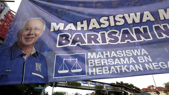Vehicles pass by a campaign poster of defeated Najib Razak on display along a street in Kuala Lumpur.