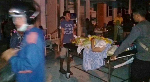 A patient is evacuated from a hospital after the earthquake hit Poso on the island of Sulawesi on Friday.