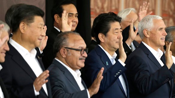 From left, Chinese President Xi Jinping, Papua New Guinea's Prime Minister Peter O'Neill, Japanese Prime Minister Shinzo Abe, and U.S. Vice President Mike Pence wave as they pose for a group photo at APEC Haus in Port Moresby, Papua New Guinea.
