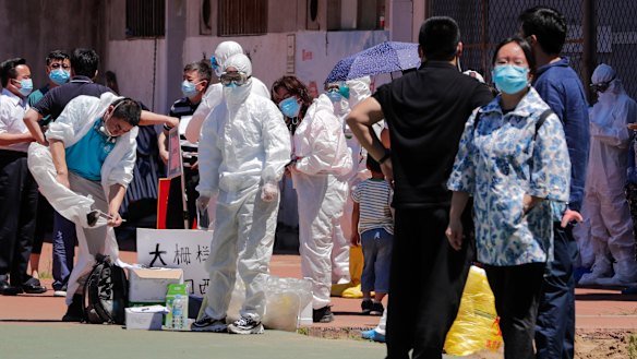 Workers put on protective suits near the Xinfadi wholesale market in Beijing.