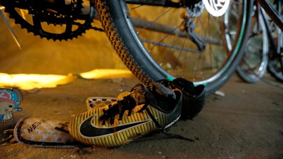 A pair of soccer boots lie next to bicycles from a group of missing boys at the entrance of a deep cave in Chiang Rai, northern Thailand.