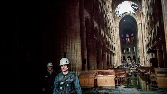 A man walks inside the damaged Notre-Dame Cathedral on Tuesday.