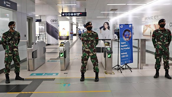 Soldiers stand guard at an MRT station in Jakarta, Indonesia.