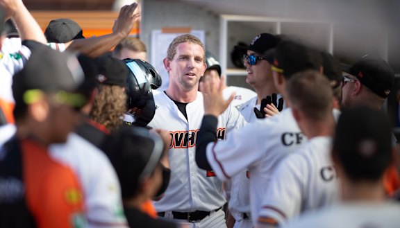 Canberra Cavalry's David Kandilas celebrates his home run in the dugout.