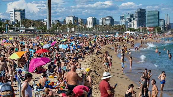 People enjoy the warm weather on the beach in Barcelona. Spanish government has announced that the north-western region of Galicia will move next week to what the government calls "the new normal".