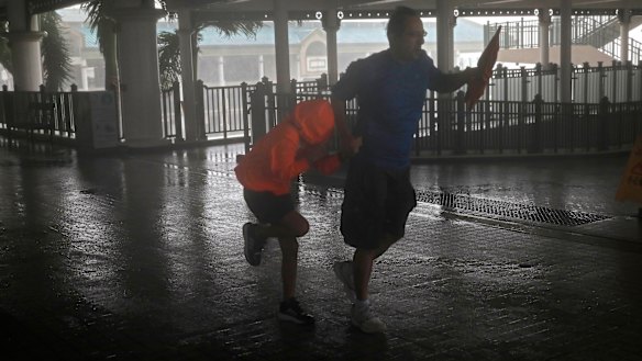 A man and a girl walk against strong winds from Typhoon Mangkhut on a pier on Victoria Habour Hong Kong, on Sunday.