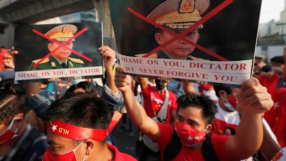 Burmese living in Thailand hold pictures of Myanmar military Commander-in-Chief Senior Gen. Min Aung Hlaing during a protest in front of the Myanmar Embassy, in Bangkok, Thailand.