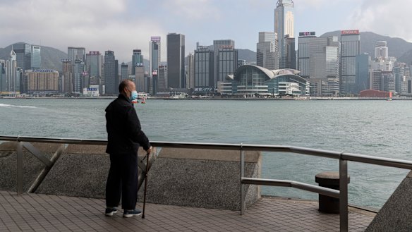 A man looking out Victoria Harbour in the very quiet and empty Tsim Sha Tsui Promenade in Hong Kong. 