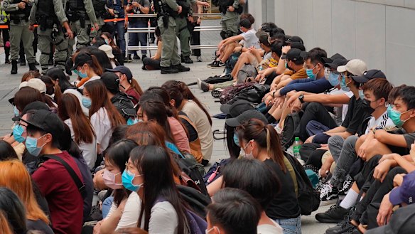 Riot police guard arrested anti-government protesters in the Central district of Hong Kong.