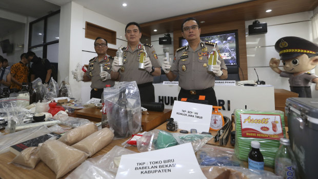 National police spokesman Brigadier general Muhammad Iqbal, centre, shows ammunition, explosive-making materials and other evidence confiscated from suspected militants.