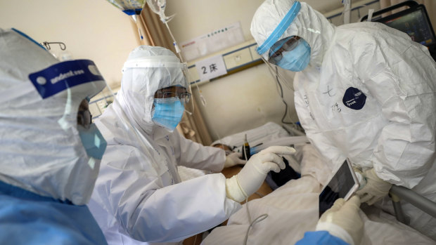 Medical personnel scan a new coronavirus patient at a hospital in Wuhan in central China's Hubei province. 