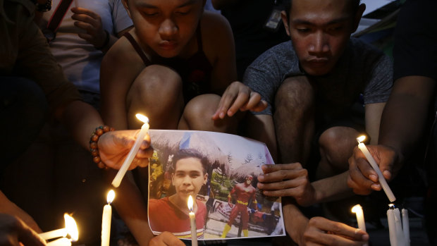 Activists light candles in front of the picture of 17-year-old student Kian Loyd delos Santos in Caloocan, metropolitan Manila on Thursday.