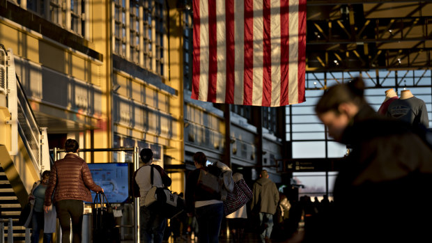Travelers walk through Ronald Reagan National Airport in Washington, DC.