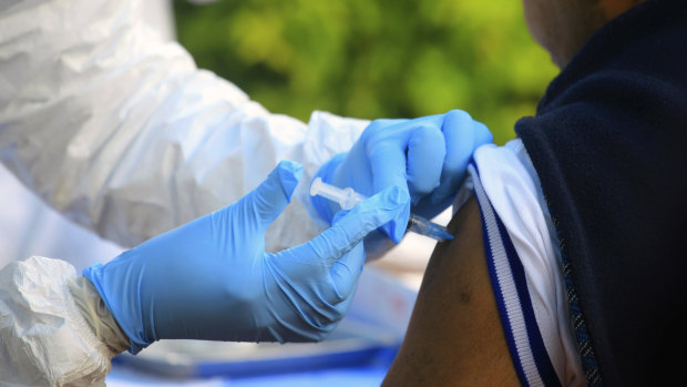 A healthcare worker from the World Health Organisation gives an Ebola vaccination to a front line aid worker in Mangina, Democratic Republic of Congo. 
