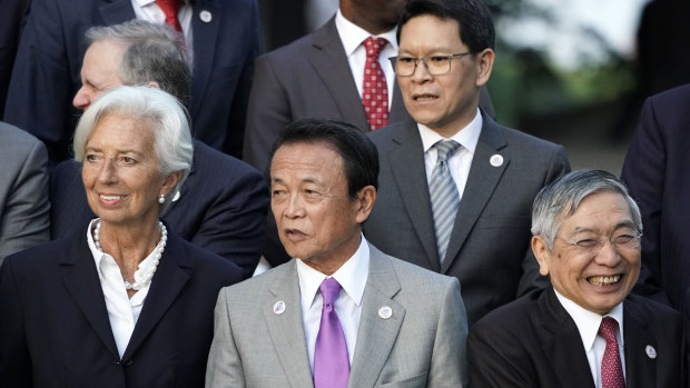 Japan's Finance Minister Taro Aso, centre, stands with IMF Managing Director Christine Lagarde, left, and Bank of Japan Governor Haruhiko Kuroda, at the G20 finance ministers event. 