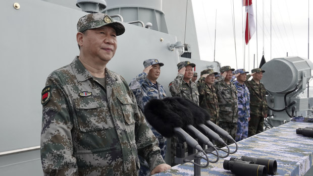 Chinese President Xi Jinping, left, prepares to address the troops after reviewing the People's Liberation Army Navy fleet in the South China Sea. 