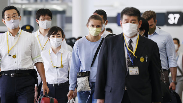 Belarusian Olympic sprinter Krystsina Tsimanouskaya, center, prepares to leave Narita International Airport in Narita, east of Tokyo.