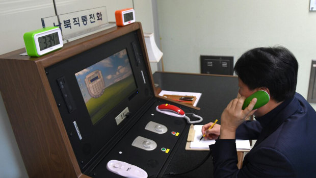 A South Korean government official communicates with a North Korean officer during a phone call on the dedicated communications hotline at the border village of Panmunjom in Paju, South Korea, before communications were cut.