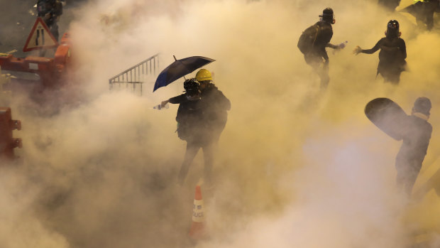 Protesters react to tear gas fired by riot policemen in Hong Kong on Sunday night.