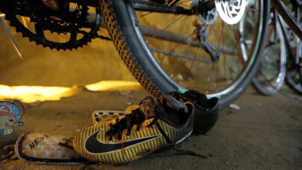 June 25, 2018: A pair of soccer boots lie next to the bicycles of the missing boys at the cave entrance in Chiang Rai, northern Thailand.