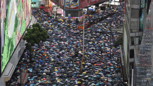 Demonstrators carry umbrellas as they march along a street in Hong Kong.