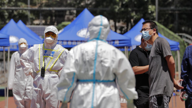 A policeman wearing a protective suit stands watch at the Xinfadi wholesale market. 