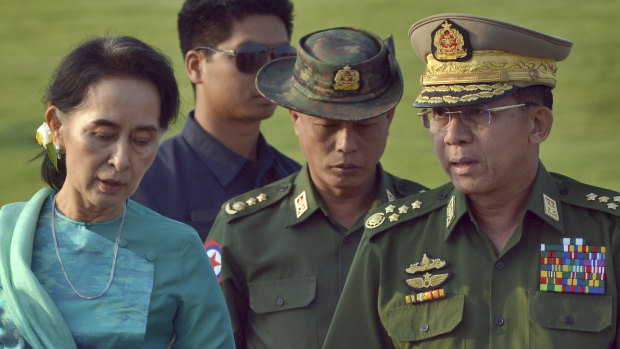 Aung San Suu Kyi, left, walks with Senior General Min Aung Hlaing, right, in 2016