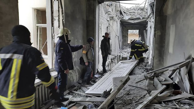 Emergency service personnel inspecting the damage inside the City Hall building in Kharkiv.